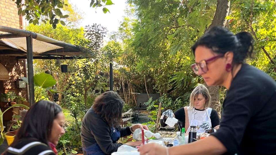 Clase en la Casa Taller de Andrea Muñiz — alumnas creando esculturas en el jardín